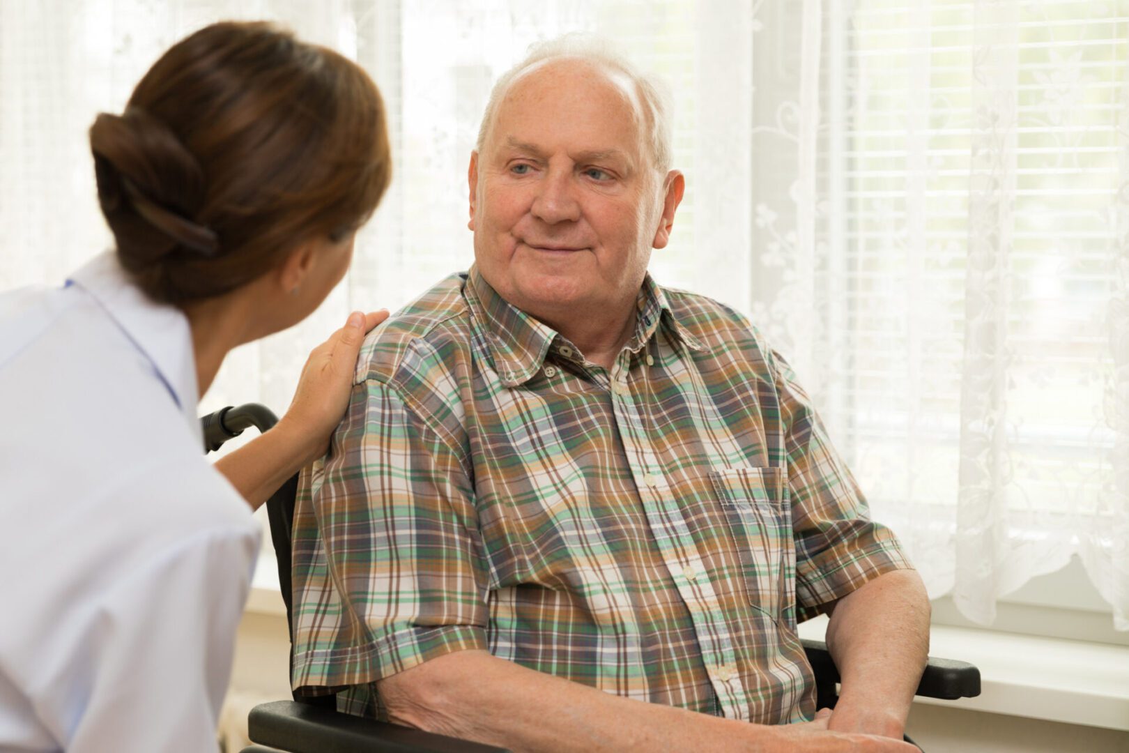 Nurse talking to older man in home